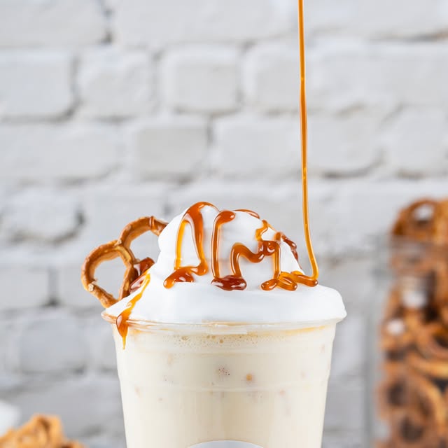 Caramel pretzel milkshake topped with whipped cream, a pretzel, and caramel drizzle